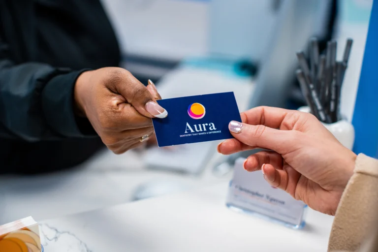 two women exchanging cards at Aura dental new york